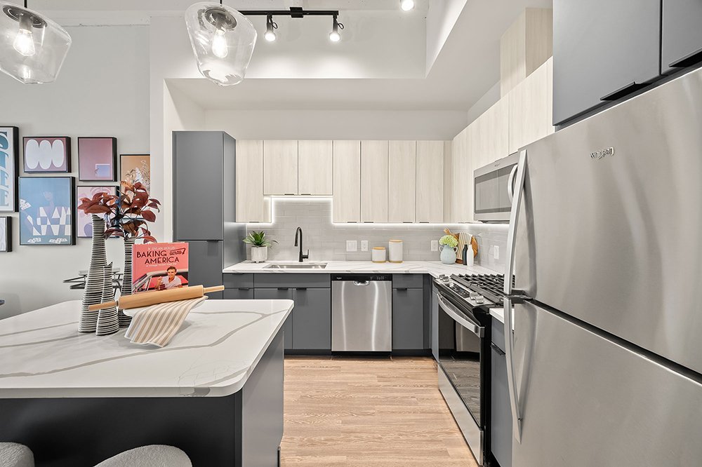 Designer kitchen with under-cabinet lighting and stainless steel appliances in our high-rise luxury apartments in Houston.