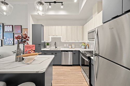 Luxe kitchen layouts with under-cabinet lighting, large kitchen island, gas range, and beverage center.